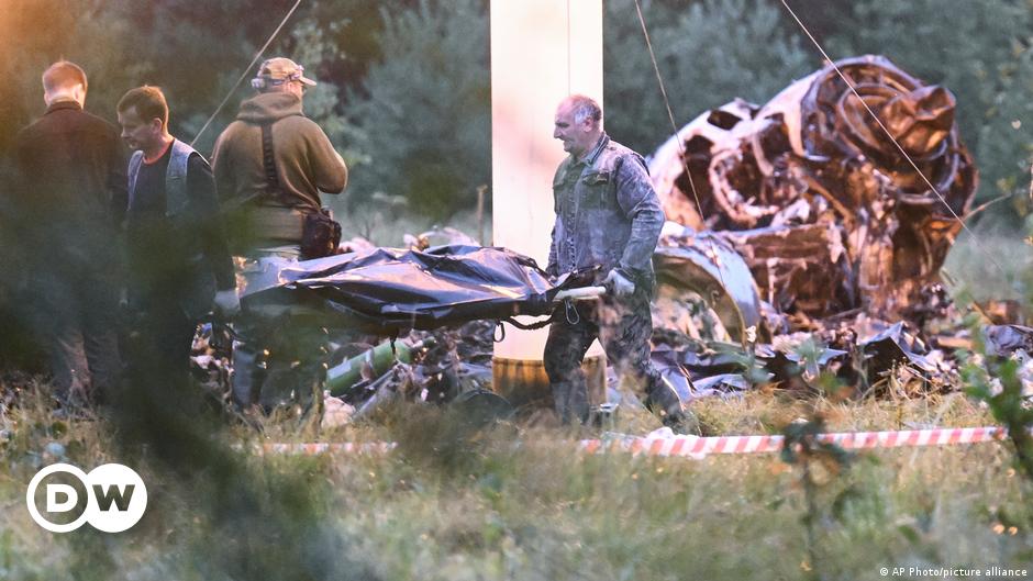 People carry a body bag away from the wreckage of a crashed private jet, near the village of Kuzhenkino, Tver region, Russia, Thursday, Aug. 24, 2023.
