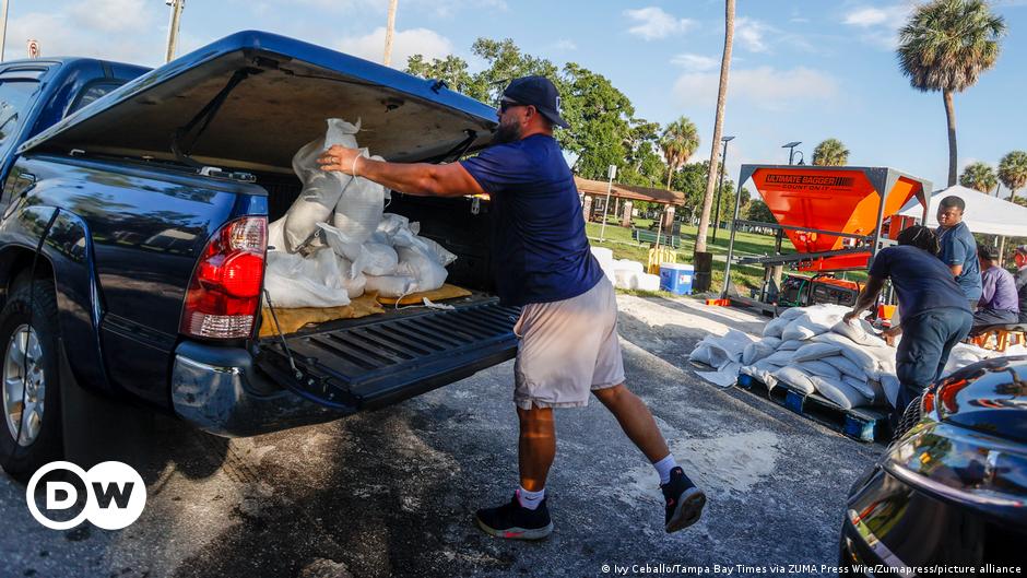 DAYTONA BEACH, FLORIDA - NOVEMBER 10: (L-R) Troy Brown, Devin Padden and Michelle Padden stand in their home surrounded by flood water after Hurricane Nicole came ashore on November 10, 2022 in Daytona Beach, Florida.
