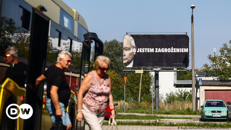A poster shows a child with his hand in front of his mouth and includes the slogans 'Give our children back their language!' and 'one is not equal to three'
