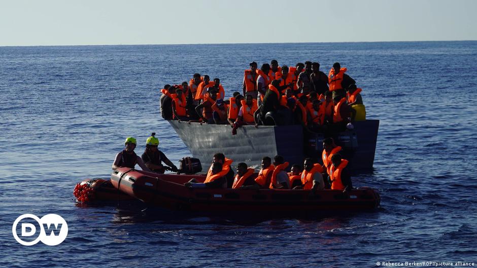 A rescue worker helps a child from a group of mainly Syrian migrants during a mission