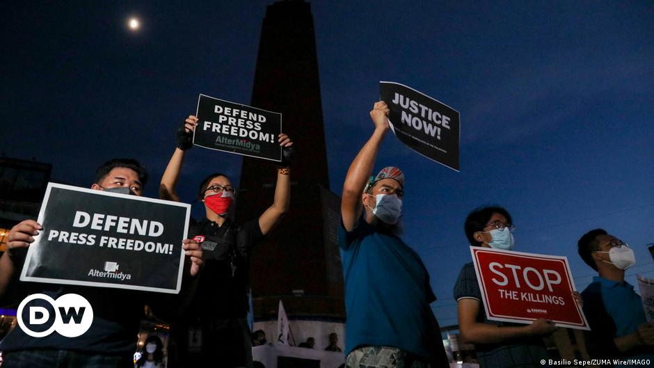 Two police officers detain Myanmar journalist at protest rally