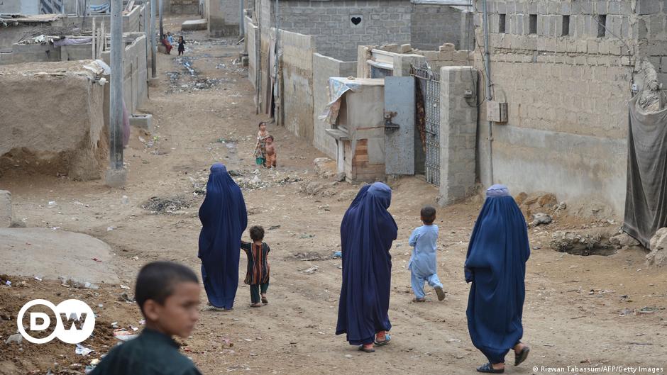 Men with children on their shoulders wearing raincoats