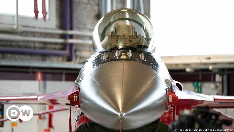 A Ukrainian soldier standing next to a multiple barrel rocket launcher