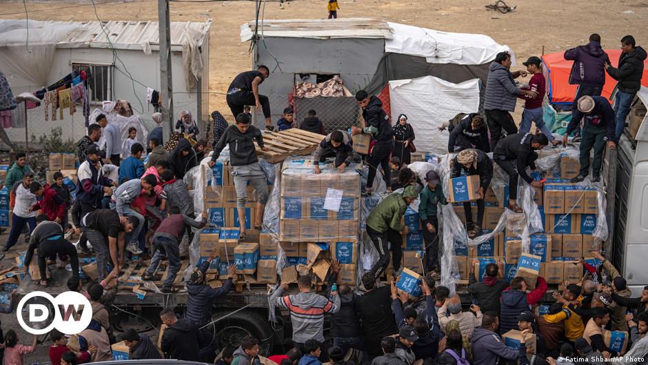 People try to set up shelters on muddy ground with makeshift tents
