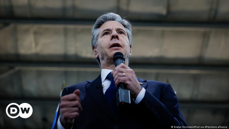 Jean-Pierre Lacroix, in glasses and coat and tie, sits in a chair and looks at the camera