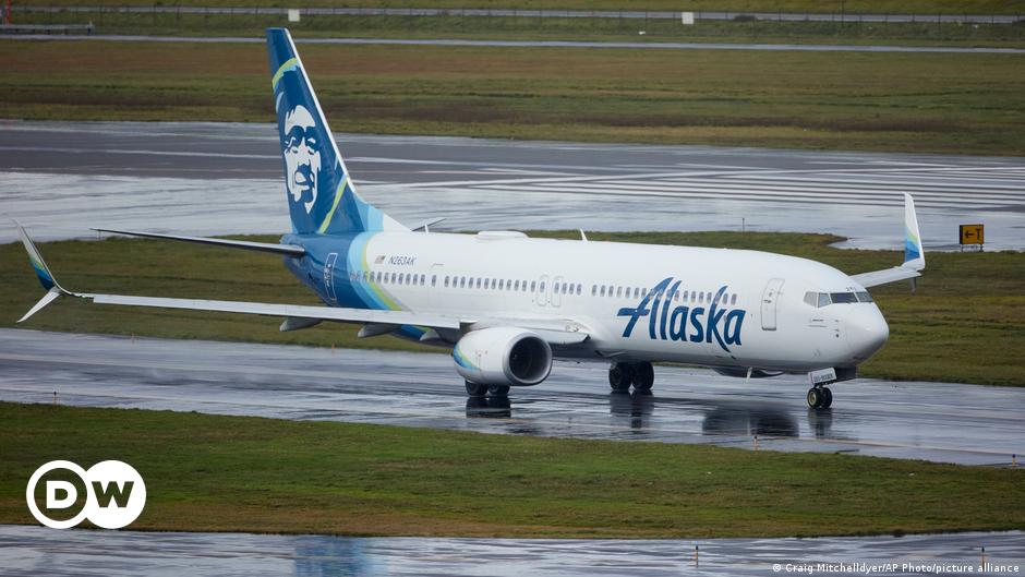 An investigator examines the frame on a section of Alaska Airlines Flight 1282 that is missing panel on a Boeing 737-9 MAX in Portland