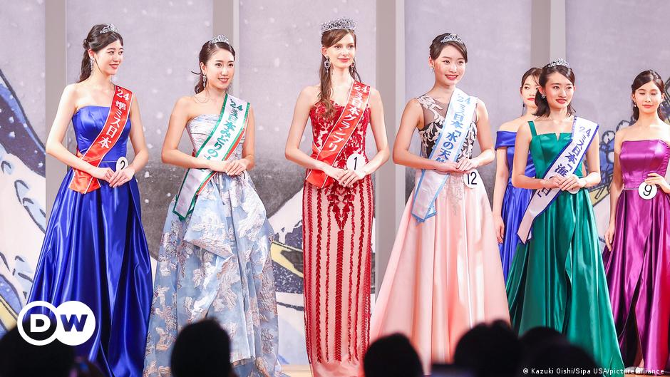 Saskia von Bargen smiles, behind her is pink neon lettering.