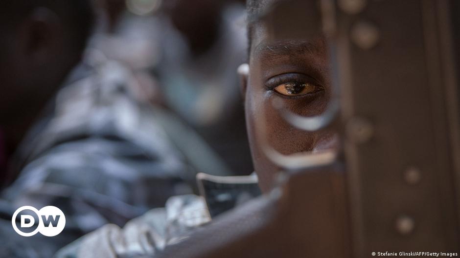 A team of former child soldiers gather around the borehole to finish drilling their new well in Bangui