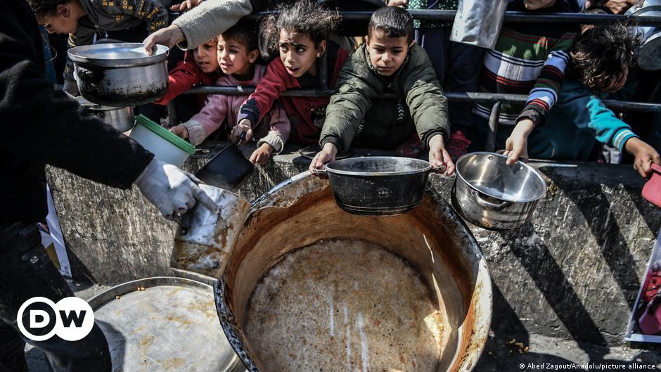 Three men sit atop the rubble of destroyed houses of the Jabalia camp for Palestinian refugees