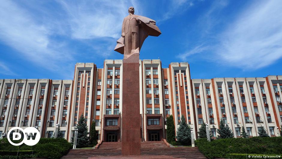Headshot of a smiling man with glasses and blond, curly hair